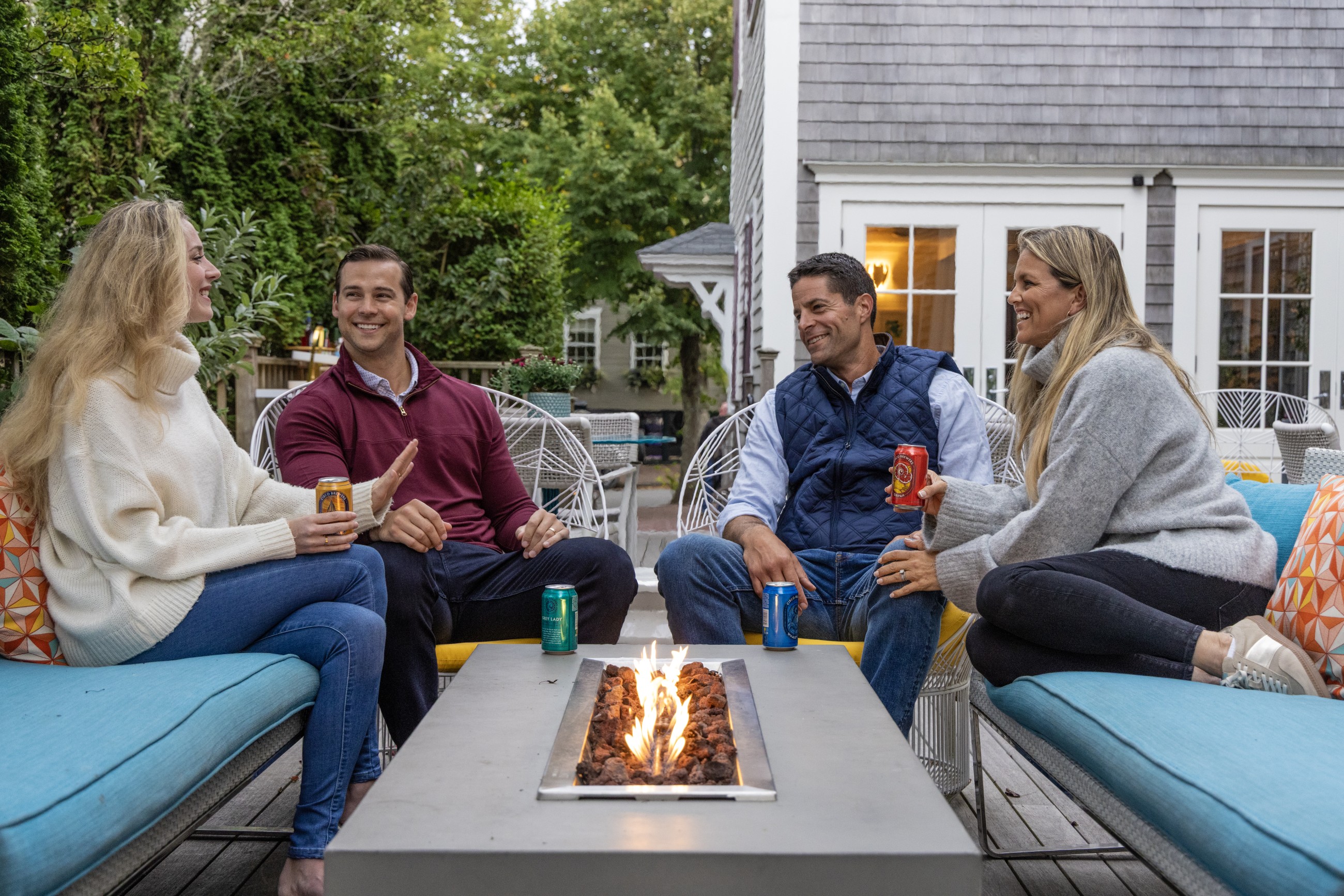 Couples sitting around a fire on the back porch of 21 Broad