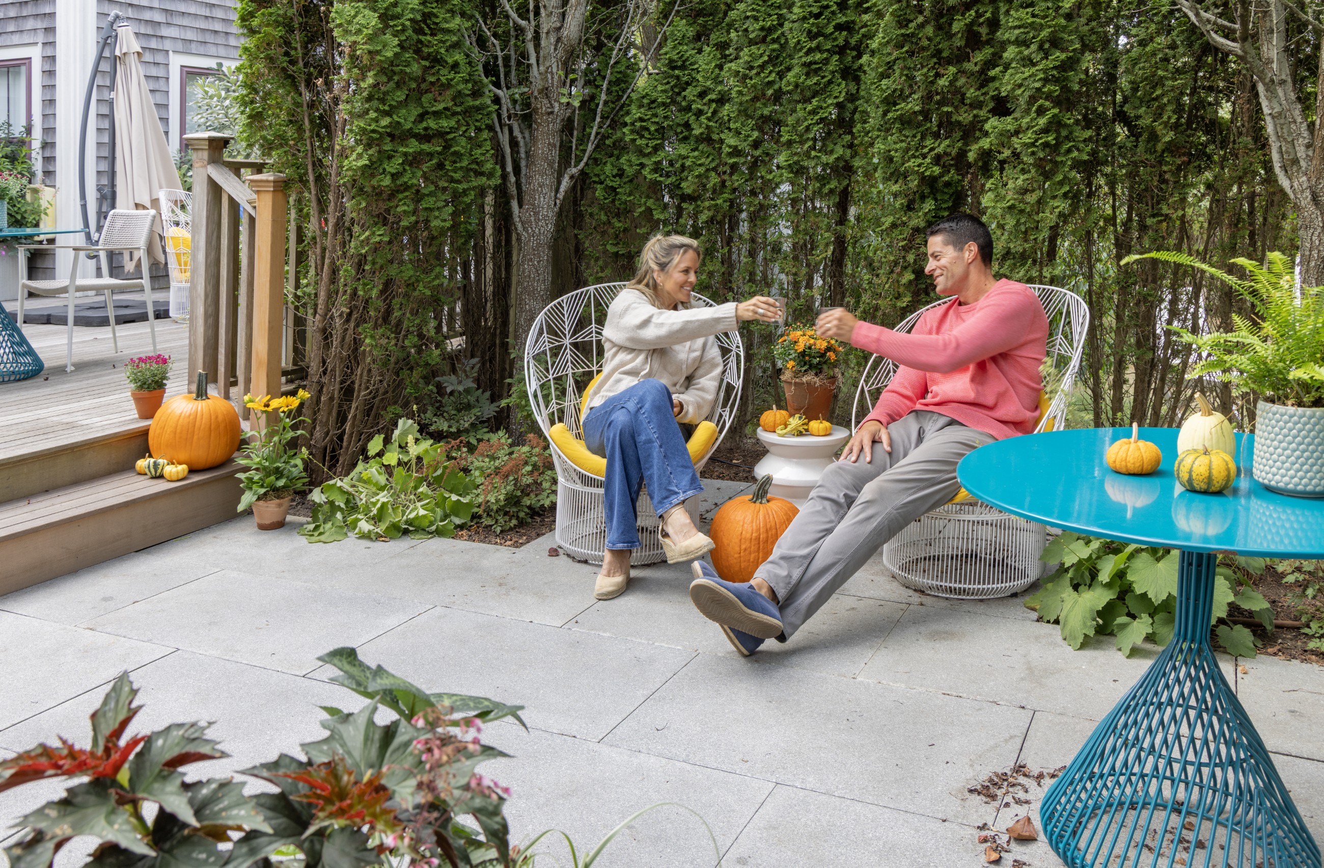 Couple clinking their glasses together on the back porch of 21 Broad Hotel